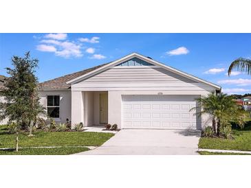 Charming single-story home featuring a two-car garage, well-manicured lawn, and beautiful landscaping at 1590 Sage Ave, Haines City, FL 33844