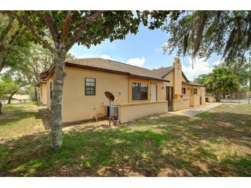 Side view of the townhome featuring well-maintained grounds and lovely landscaping at 56 Pine Trak # 101E, Ocala, FL 34472