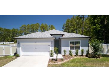 Charming single-story home featuring a two-car garage, fresh landscaping, and a cozy, welcoming entrance at 8007 Sw 135Th Loop, Ocala, FL 34473