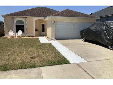 Inviting single-story home featuring a well-manicured lawn and attached two-car garage at 2057 Swift Rd, Oviedo, FL 32766