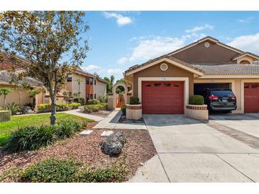 Charming townhome featuring a single-car garage, nicely landscaped yard, and warm color palette at 7759 Sugar Bend Dr # 7759, Orlando, FL 32819