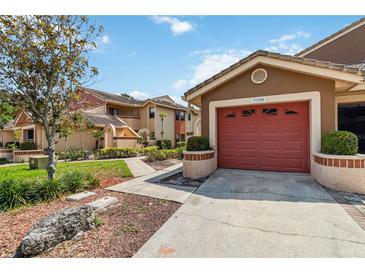Charming townhome featuring a well-manicured lawn, attached garage, and inviting curb appeal at 7759 Sugar Bend Dr # 7759, Orlando, FL 32819