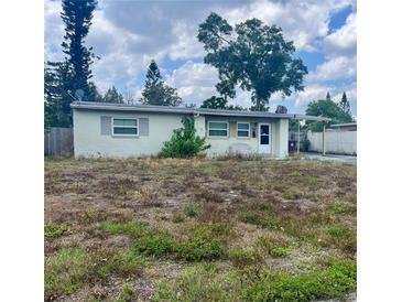 Modest single-story home with a flat roof, small windows, and front yard overgrown with weeds at 606 El Vedado Ave, Orlando, FL 32807