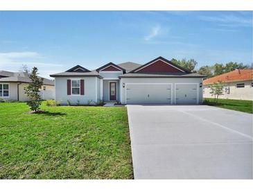 Charming single-story home with a two-car garage and a well-manicured lawn on a sunny day at 2649 Sw 176Th Loop, Ocala, FL 34473