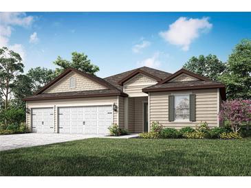 Charming single-story home featuring a three-car garage, manicured lawn, and beautiful landscaping at 2649 Sw 176Th Loop, Ocala, FL 34473