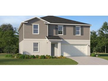 Charming two-story home with gray siding, white trim, and a two-car garage at 2434 Mckinley Dr, Lake Wales, FL 33859