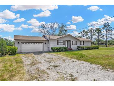 Charming single-story home with an attached garage, gravel driveway, and beautiful lawn at 2425 Anderson, Mulberry, FL 33860