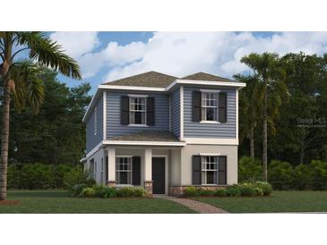 Charming two-story home featuring a stylish blue exterior, complemented by a well-maintained lawn and lush landscaping at 2899 Transformation Way, Clermont, FL 34714
