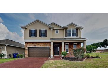 Charming two-story home featuring a stone facade, attached two-car garage, and well-manicured landscaping at 3002 Sunscape Ter, Groveland, FL 34736