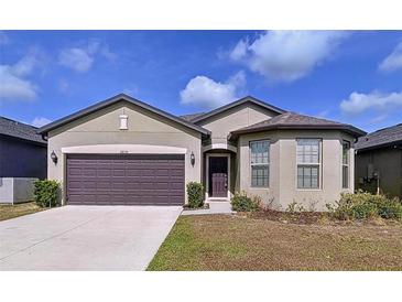 Charming one-story home featuring a two-car garage, neutral exterior, and well-maintained lawn at 8830 Fox Dr, Polk City, FL 33868
