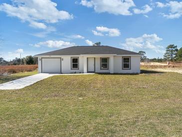Charming single-story home featuring a neatly manicured lawn and attached one car garage at 2680 Sw 144 Ct, Ocala, FL 34481