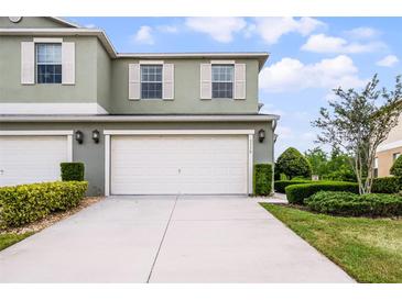 Charming two-story home with a large white garage door, well-manicured lawn and neatly trimmed hedges at 3550 Rodrick Cir, Orlando, FL 32824
