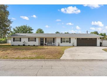Charming single-story white brick home with a well-maintained yard and attached garage at 455 W Plumosa St, Bartow, FL 33830