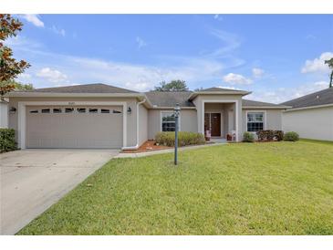 Charming single-story home featuring a well-manicured lawn, attached two car garage, and welcoming front entrance at 6523 Evergreen Park Dr, Lakeland, FL 33813