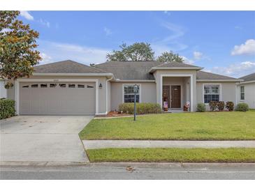 Charming single-story home features a well-manicured lawn and a welcoming front entrance with a 2 car garage at 6523 Evergreen Park Dr, Lakeland, FL 33813