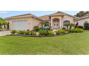 Charming single-story home featuring a lush front yard with landscaping and a two-car garage at 6442 Bendelow Dr, Lakeland, FL 33810