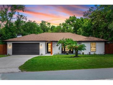 Charming single-story home features a well-maintained lawn, and an attached two-car garage at 1820 N Merrick Dr, Deltona, FL 32738
