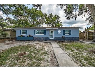 Charming single story home with blue painted wood siding and a walkway to the front door and manicured lawn at 5932 Hilltop E Ln, Lakeland, FL 33809