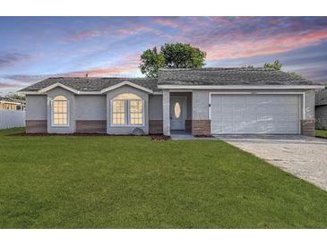Charming single-story home featuring a well-manicured lawn, gray exterior, and attached two-car garage at 2769 Corrigan Dr, Deltona, FL 32738
