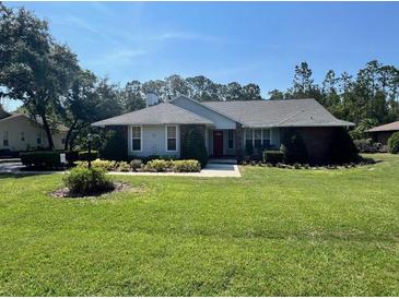 Well-maintained single-story home featuring a brick facade and a neatly manicured lawn at 2528 Deerbrook Dr, Lakeland, FL 33811