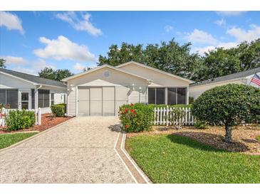 Charming single-story home with a well-manicured lawn and colorful landscaping at 2121 Escobar Ave, Lady Lake, FL 32159