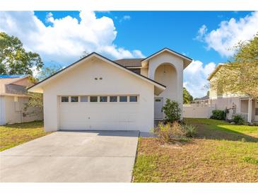 Charming two-story home featuring an attached two-car garage and well-manicured lawn under a bright blue sky at 728 Waterbridge Dr, Winter Haven, FL 33880