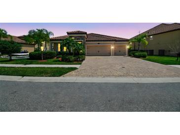 Charming single-story home with a brick driveway, tile roof, manicured landscaping, and a two-car garage at 1839 Via Lago Dr, Lakeland, FL 33810