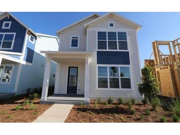 Charming two-story home with a modern design, large windows, and a welcoming front porch at 6690 Wake St, St Cloud, FL 34771