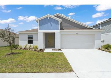 Charming single-Gathering home featuring a modern exterior with a two-car garage and well-maintained lawn at 5933 Slate Rock Dr, Lakeland, FL 33811