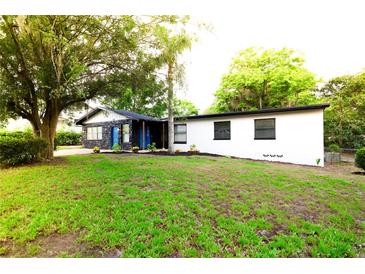 Charming home featuring a lush green lawn and mature trees, offering a serene and inviting curb appeal at 808 S Clara Ave, Deland, FL 32720