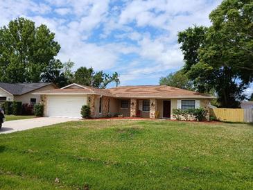 Charming single-story home with a well-maintained lawn and attached garage at 2414 Willow Oak Dr, Edgewater, FL 32141