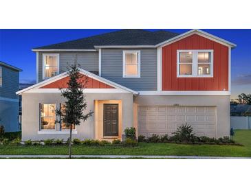 Charming two-story home with a well-manicured lawn and an attached two-car garage at 1609 Sage Ave, Haines City, FL 33844