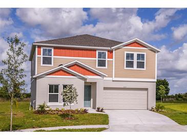 Two-story home featuring a two-car garage, neutral paint, and a well-manicured lawn at 1617 Sage Ave, Haines City, FL 33844