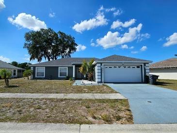 Charming single-story home with a well-manicured lawn, a two car garage, and a nicely painted exterior at 205 Golf Aire Blvd, Haines City, FL 33844