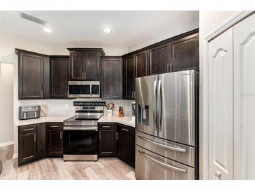 Modern kitchen featuring stainless steel appliances and dark cabinets, providing ample storage at 6050 Eagle Pointe Dr, Lakeland, FL 33812