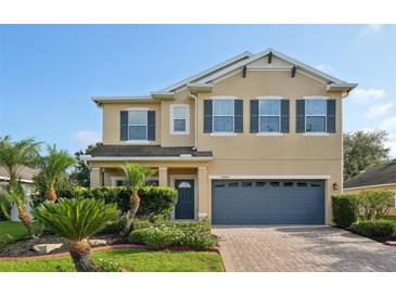 Inviting two-story home with a well-manicured lawn, brick driveway, and covered entryway at 3848 Spirited Cir, St Cloud, FL 34772