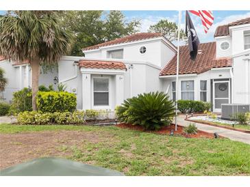 Home featuring green landscaping, a red tile roof, white stucco, and a black flag at 2524 Albion Ave, Orlando, FL 32833