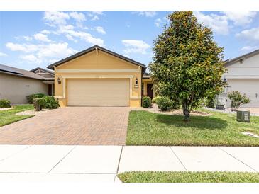 Charming single-Gathering home with a two-car garage, brick driveway, and beautiful landscaping at 472 Pontevedra Rd, Davenport, FL 33837