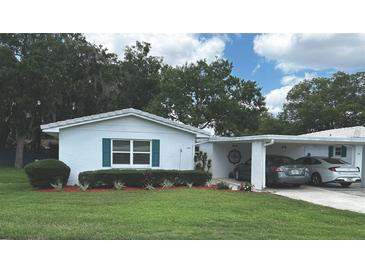 Charming single story home featuring a well-manicured lawn and covered parking at 730 Barber Cir, Lakeland, FL 33803