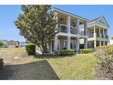 Charming two-story home showcasing a large tree and expansive lawn at 7523 Excitement Dr, Kissimmee, FL 34747