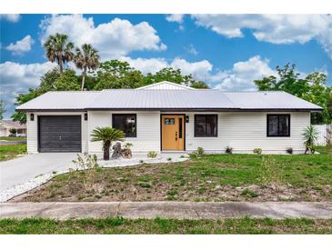 Charming home featuring a metal roof, freshly painted exterior, updated landscaping and an attached garage at 1161 Orangewood Ave, Deland, FL 32724