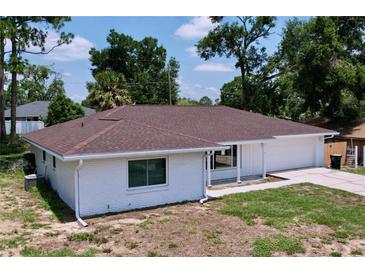 Charming single-story home featuring a brick exterior, new brown roof, attached garage and well-maintained landscaping at 212 Overlook Dr, Winter Haven, FL 33884
