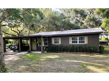 Charming single-story home with brown exterior, covered carport, well maintained landscaping, and a metal roof at 2748 Cr 543, Sumterville, FL 33585