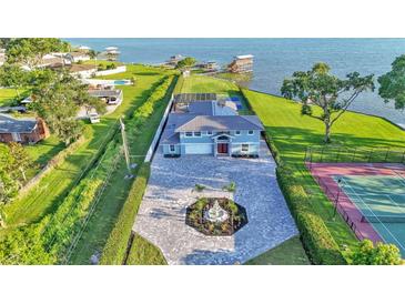 Stunning waterfront home with well manicured grounds, spacious driveway, water access and pool and tennis court at 390 Windermere Dr, Lakeland, FL 33809