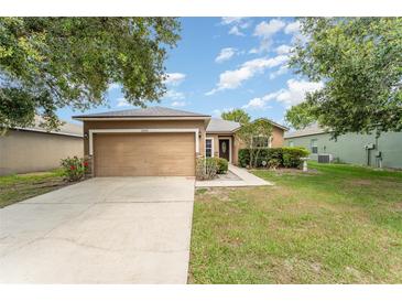 Charming single-story home features a well-maintained lawn, a two-car garage, and beautiful landscaping at 6898 Glenbrook Dr, Lakeland, FL 33811