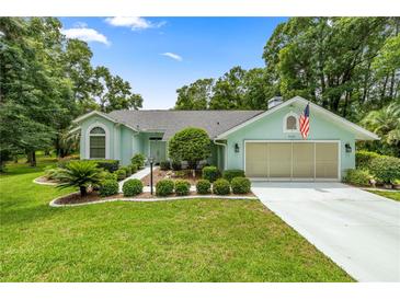 Charming single-story home with a well-maintained lawn, landscaping, and a two-car garage at 9530 Sw 189Th Ct, Dunnellon, FL 34432