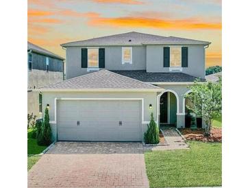 Charming two-story home with a well-maintained lawn, a two-car garage, and beautiful landscaping at 1521 Sourwood Dr, Ocoee, FL 34761