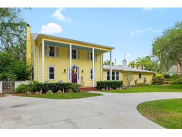 Charming yellow two-story home with a covered front porch, lush landscaping, and a welcoming driveway at 1226 Se 9Th Ave, Ocala, FL 34471