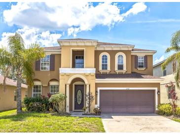 Charming two-story home with a well-maintained lawn, beautiful landscaping, and attached two-car garage at 1769 Strathmore Cir, Mount Dora, FL 32757