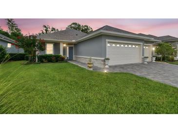 Charming home featuring a well-manicured lawn, a gray exterior, and a convenient two-car garage at 7991 Lake James Blvd, Lakeland, FL 33810